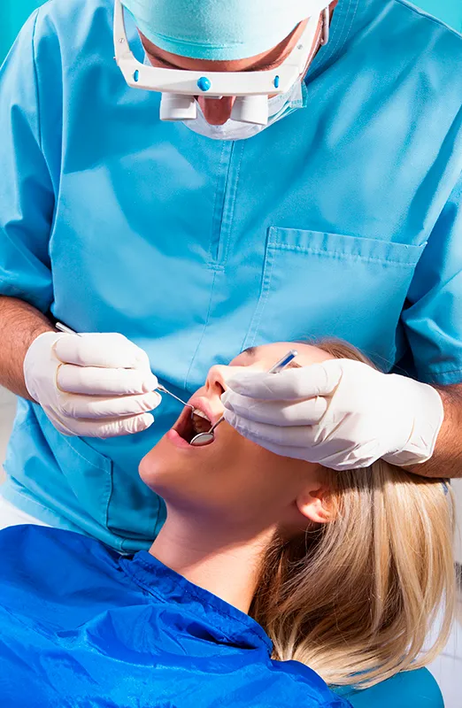 Dentist checking mouth with mirror and pick